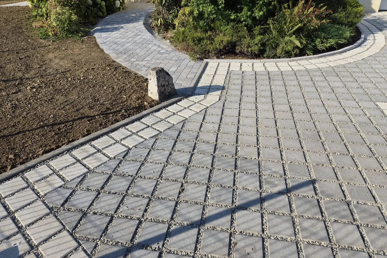 Allée pavée en courbe autour d’un massif