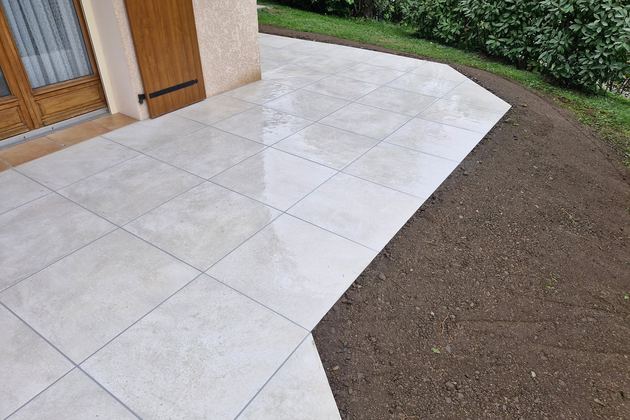 Terrasse en grands carreaux clairs devant l’entrée d’une maison
