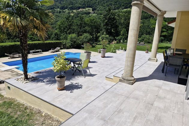 Terrasse dallée sous colonnade avec vue sur la vallée