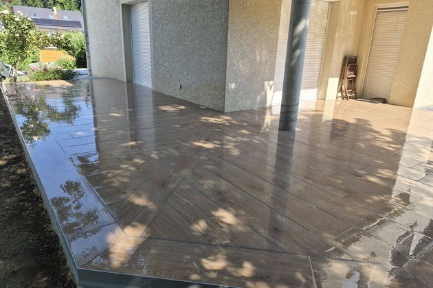 Terrasse dallée couverte au pied d’une maison
