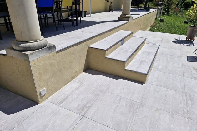 Terrasse dallée avec marches devant une véranda