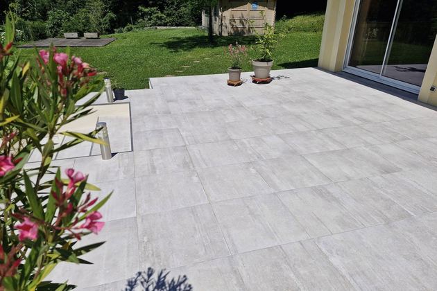 Terrasse dallée claire et massif fleuri