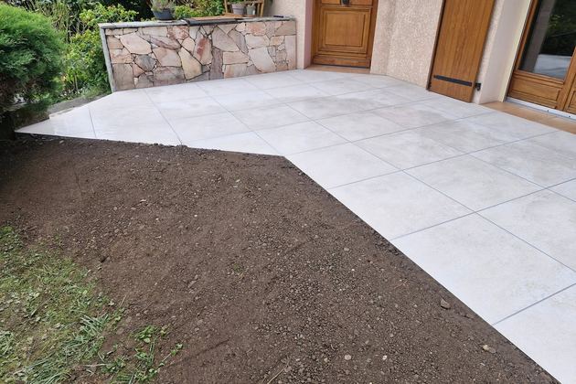 Terrasse dallée claire au pied d’une façade